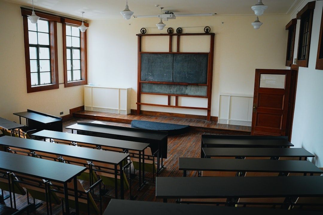 Historiskt klassrum med svarta tavlan och rader av elevbänkar
